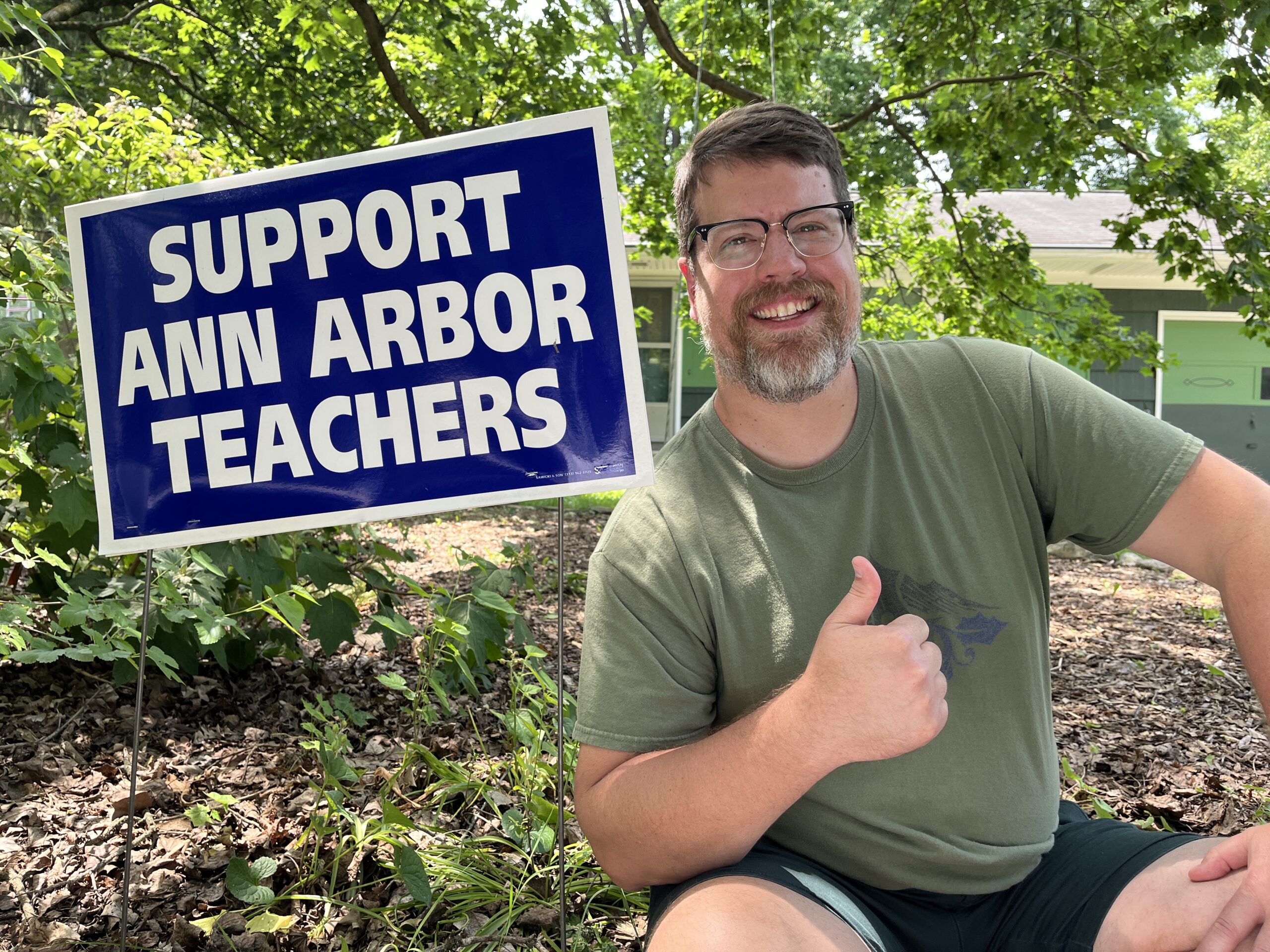 Chris in front of a Support Ann Arbor Teachers sign